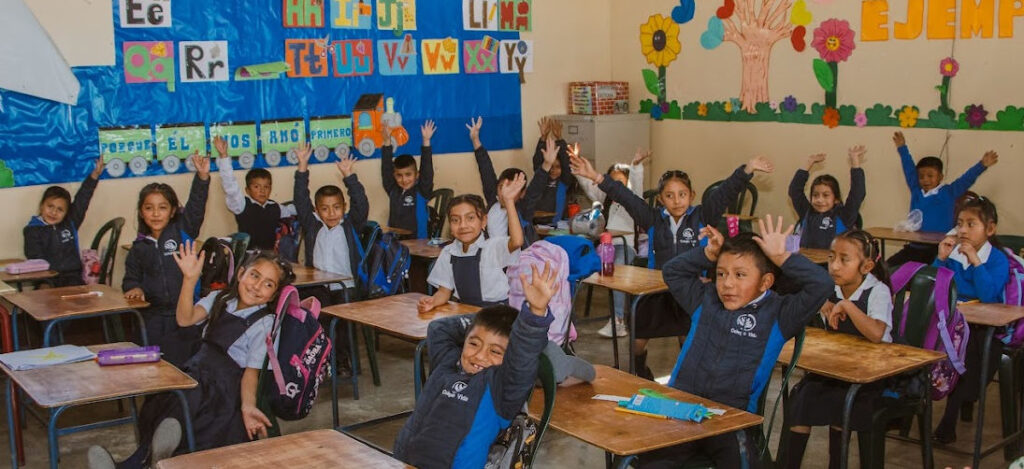 Children in a Vida classroom raising their hands