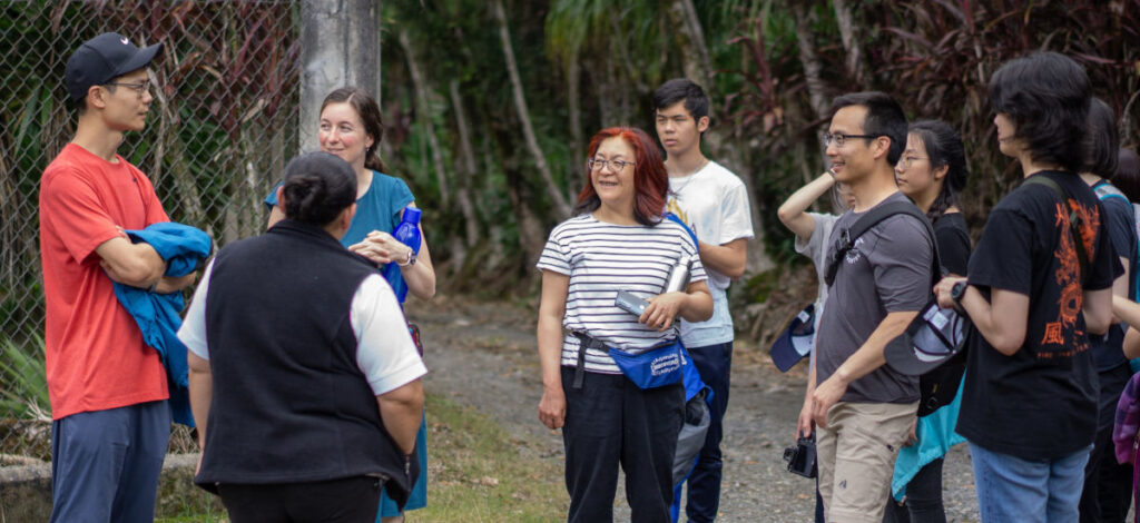 www.mylifeimpacted.impactministries.ca Mission team members standing in a circle outside listening as Guatemalan missionary Julie shares