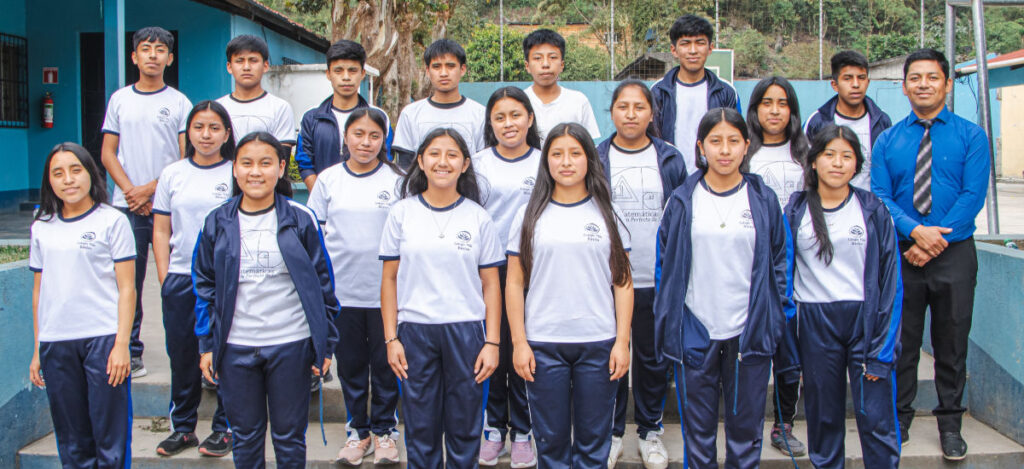 A class of junior high students and their teacher posing for their support a class picture