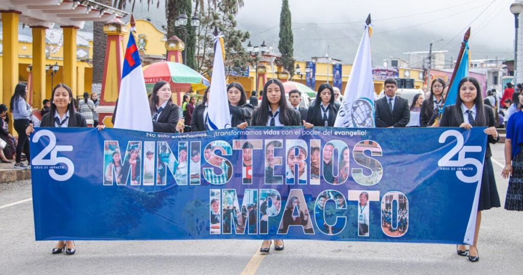 Vida Junior High Students in School Uniform parading with a "25 Ministerios Impacto" banner